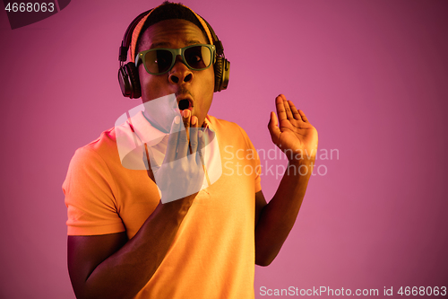 Image of The young handsome hipster man listening music with headphones