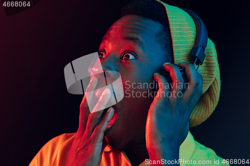 Image of The young handsome hipster man listening music with headphones