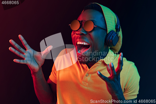 Image of The young handsome hipster man listening music with headphones