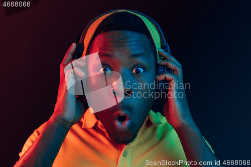 Image of The young handsome hipster man listening music with headphones