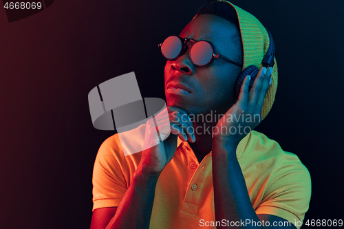 Image of The young handsome hipster man listening music with headphones