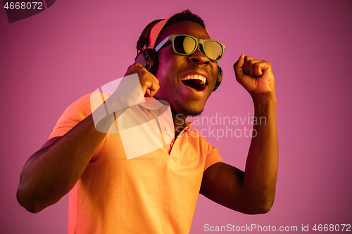 Image of The young handsome hipster man listening music with headphones