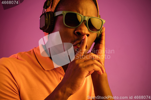 Image of The young handsome hipster man listening music with headphones