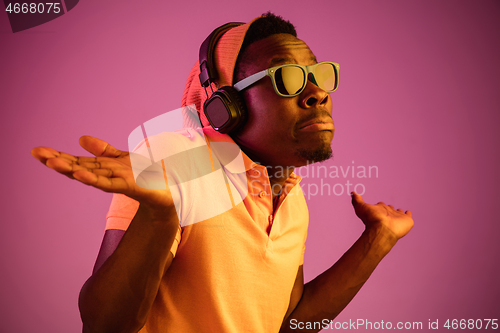 Image of The young handsome hipster man listening music with headphones