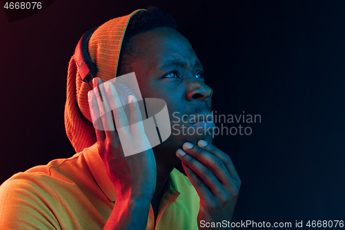 Image of The young handsome hipster man listening music with headphones