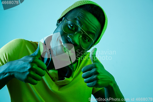 Image of The young handsome hipster man listening music with headphones