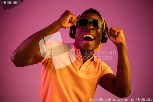 Image of The young handsome hipster man listening music with headphones