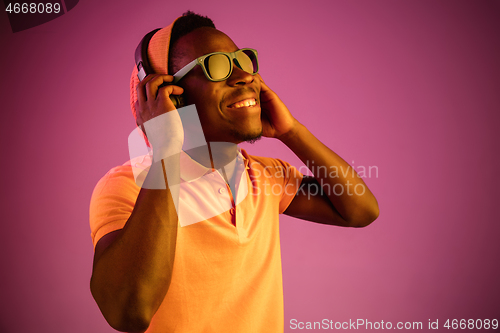 Image of The young handsome hipster man listening music with headphones