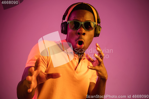 Image of The young handsome hipster man listening music with headphones