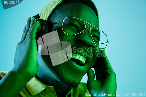 Image of The young handsome hipster man listening music with headphones