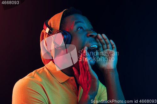 Image of The young handsome hipster man listening music with headphones