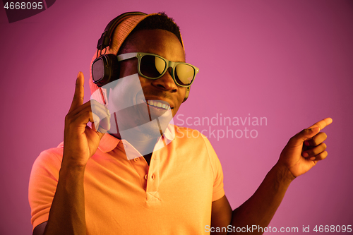 Image of The young handsome hipster man listening music with headphones