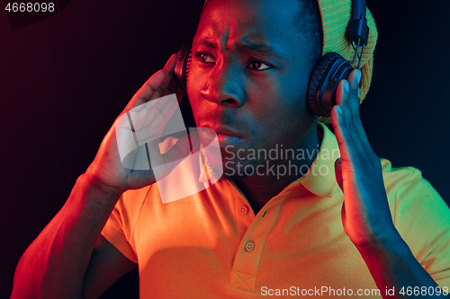 Image of The young handsome hipster man listening music with headphones