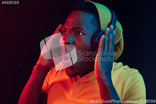 Image of The young handsome hipster man listening music with headphones