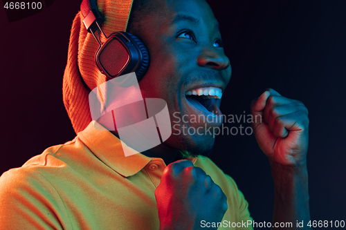 Image of The young handsome hipster man listening music with headphones