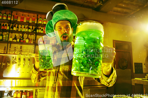 Image of Happy man with glass of beer looking aside in pub