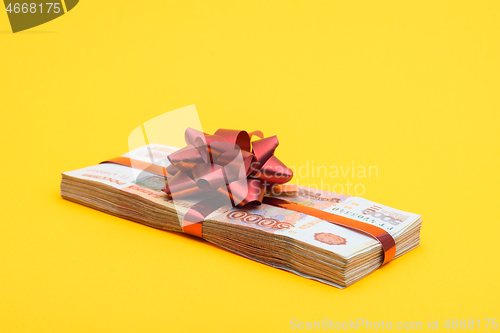 Image of On a yellow background lies a gift pack of five thousandth Russian bills