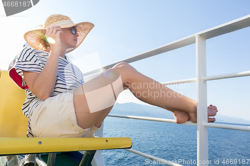 Image of Beautiful, romantic blonde woman taking selfie self portrait photo on summer vacations traveling by cruse ship ferry boat.