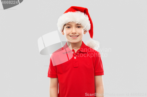 Image of smiling boy in red t-shirt and santa helper hat