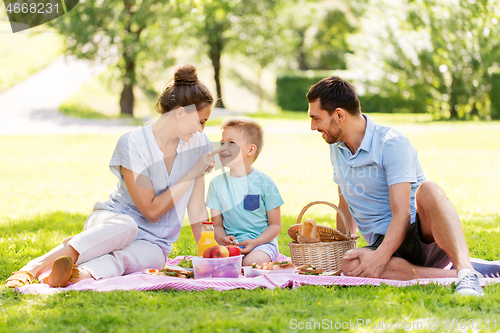 Image of happy family having picnic at summer park