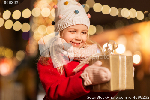 Image of happy girl with gift box at christmas market