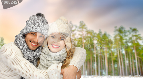 Image of couple hugging over winter forest background