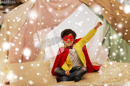 Image of happy boy in super hero stuff in kids tent at home