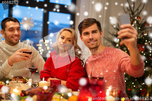 Image of friends taking selfie at christmas dinner