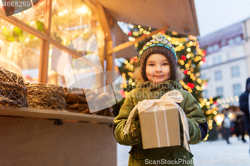 Image of happy boy with gift box at christmas market