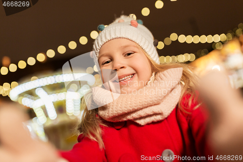 Image of little girl taking selfie at christmas market