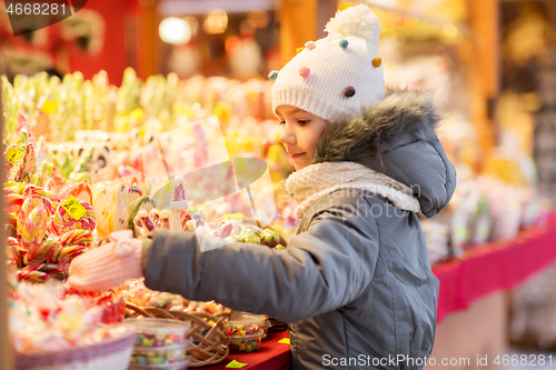 Image of little girl choosing sweets at christmas market