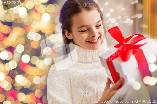 Image of happy beautiful girl with christmas gift at home