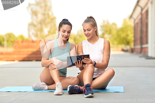 Image of sporty women or friends with tablet pc on rooftop