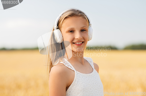 Image of happy girl in headphones on cereal field in summer