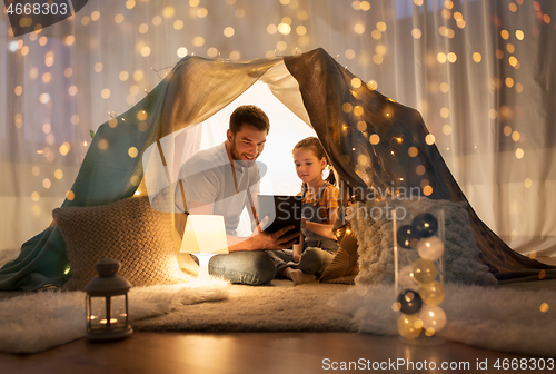 Image of family with tablet pc in kids tent at home