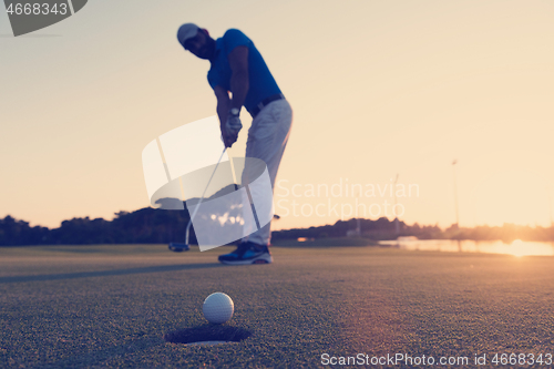 Image of golfer  hitting shot at golf course