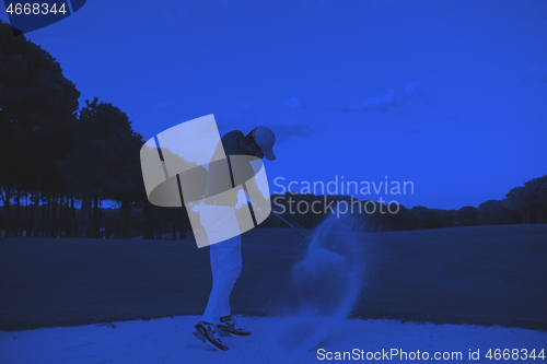 Image of golfer hitting a sand bunker shot on sunset