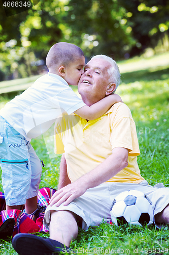 Image of grandfather and child have fun  in park