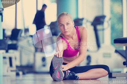 Image of woman stretching and warming up for her training at a gym