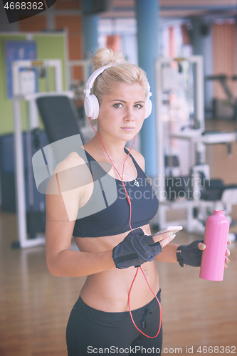 Image of woman with headphones in fitness gym