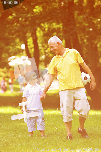 Image of happy grandfather and child in park