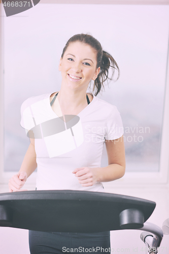 Image of womanworkout  in fitness club on running track machine 
