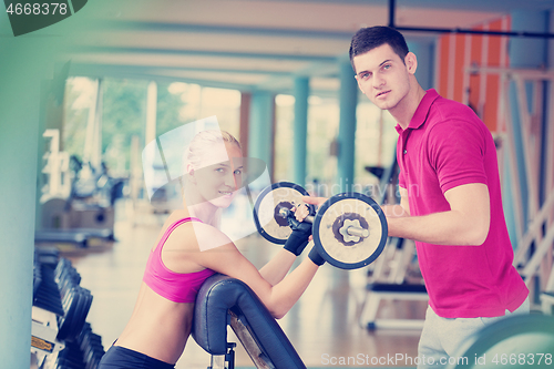 Image of young sporty woman with trainer exercise weights lifting