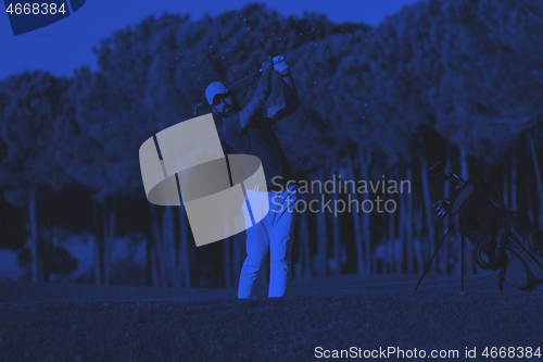 Image of golfer hitting a sand bunker shot on sunset