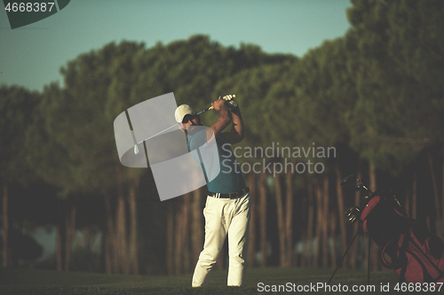 Image of golfer hitting a sand bunker shot on sunset