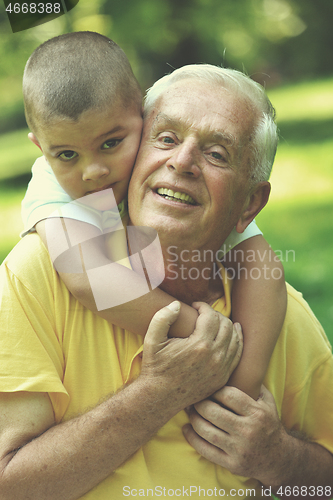 Image of happy grandfather and child in park