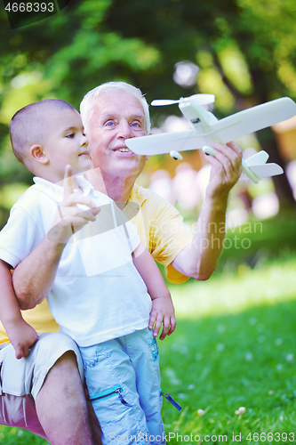 Image of happy grandfather and child in park