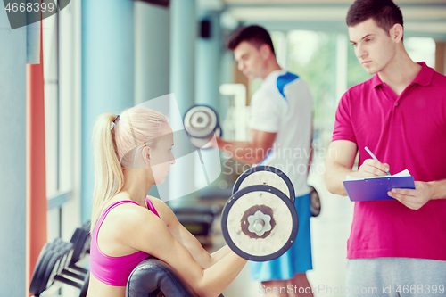 Image of young sporty woman with trainer exercise weights lifting