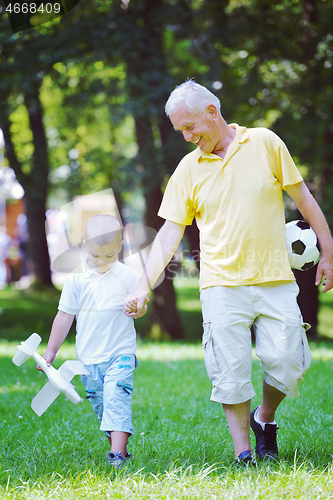 Image of happy grandfather and child in park