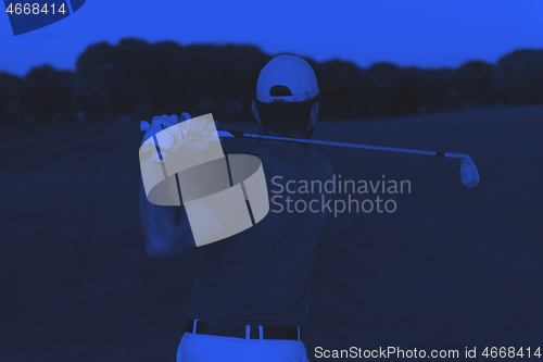 Image of golfer hitting a sand bunker shot on sunset